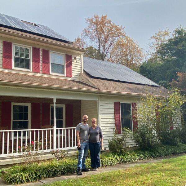 couple in front of home with new solar panels