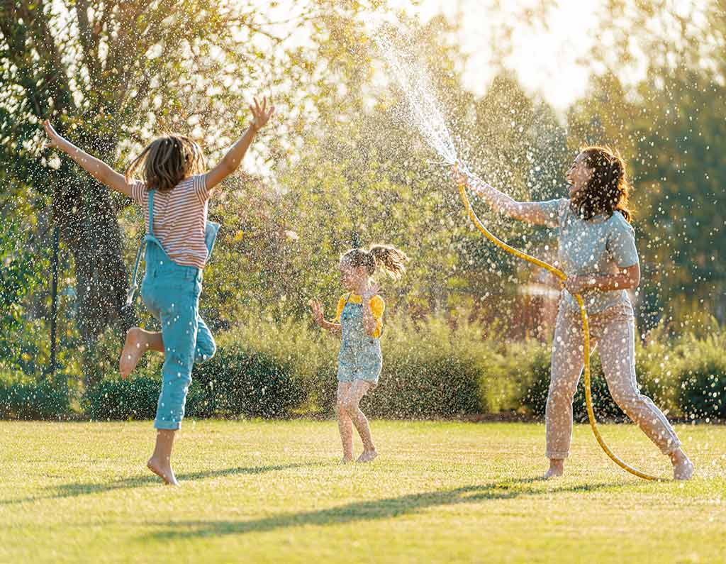 happy family playing in the backyard with water
