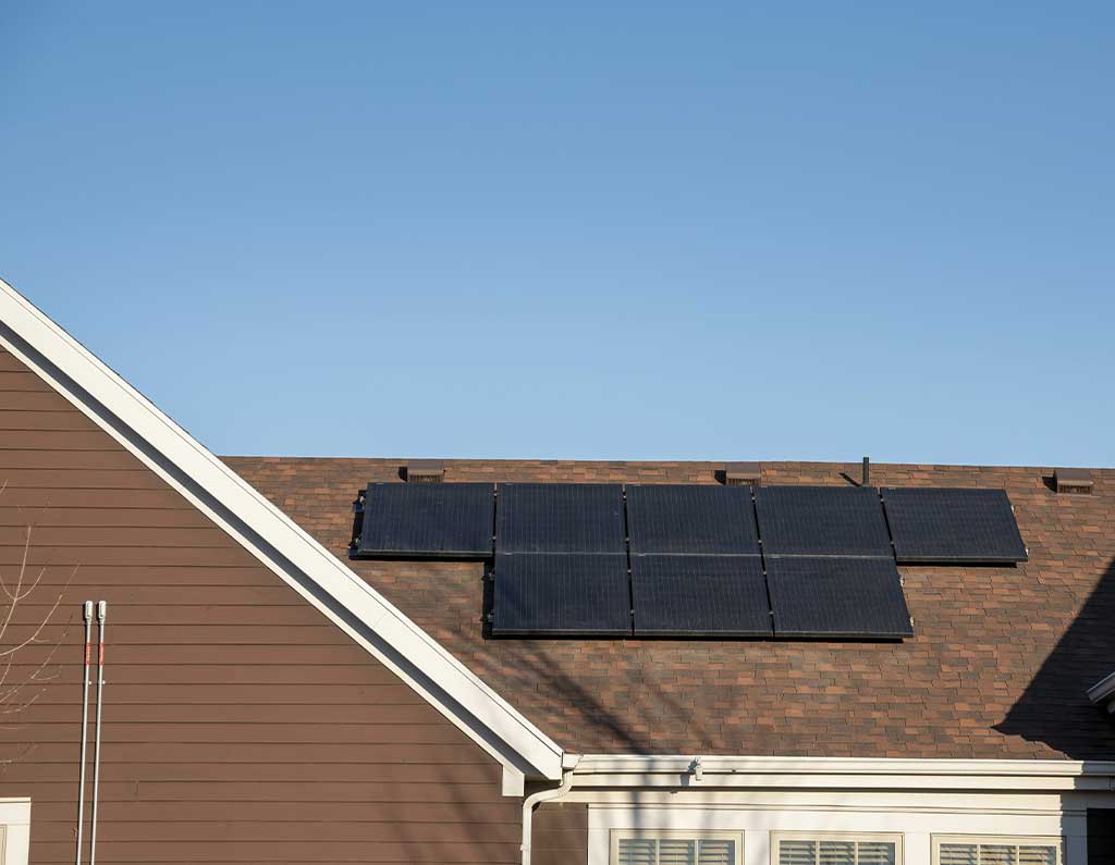 roof with brown shingles on roof and solar panel installation