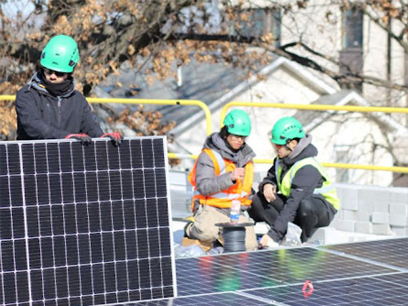 professional solar installers on roof of a building