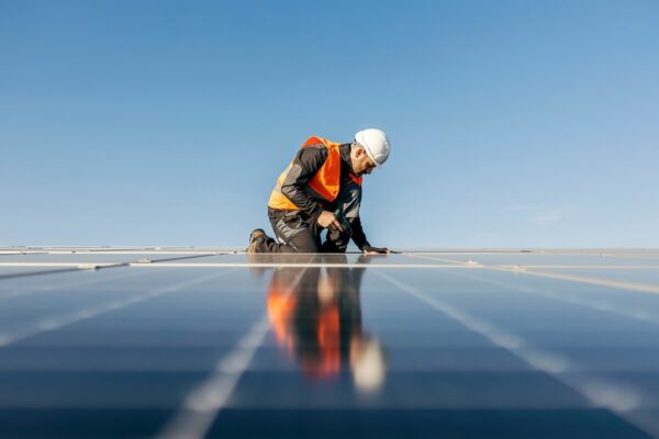 worker kneeling and sets solar panel in Maryland